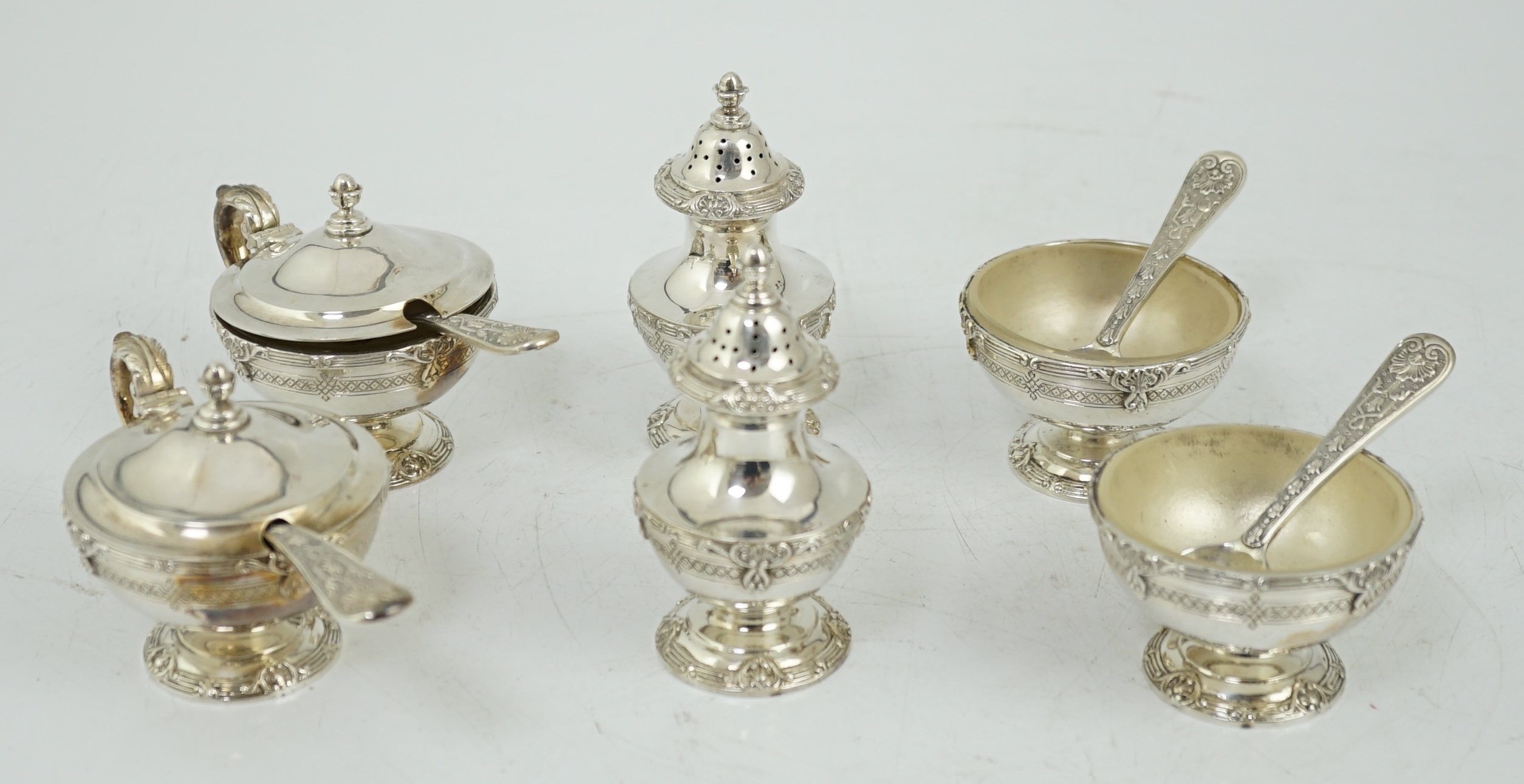 An Elizabeth II cased silver six piece pedestal condiment set, with four matching spoons, by Garrard & Co